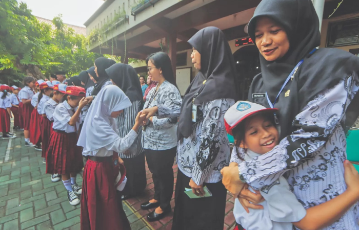 Siswa memeluk guru saat peringatan Hari Guru Nasional 2024 di salah satu SD di Kota Solo.