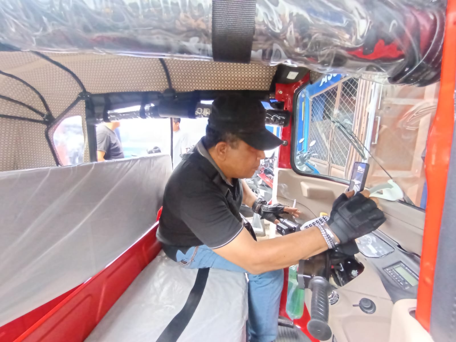 Driver Bajaj Maxride mengecek aplikasi di smartphone.