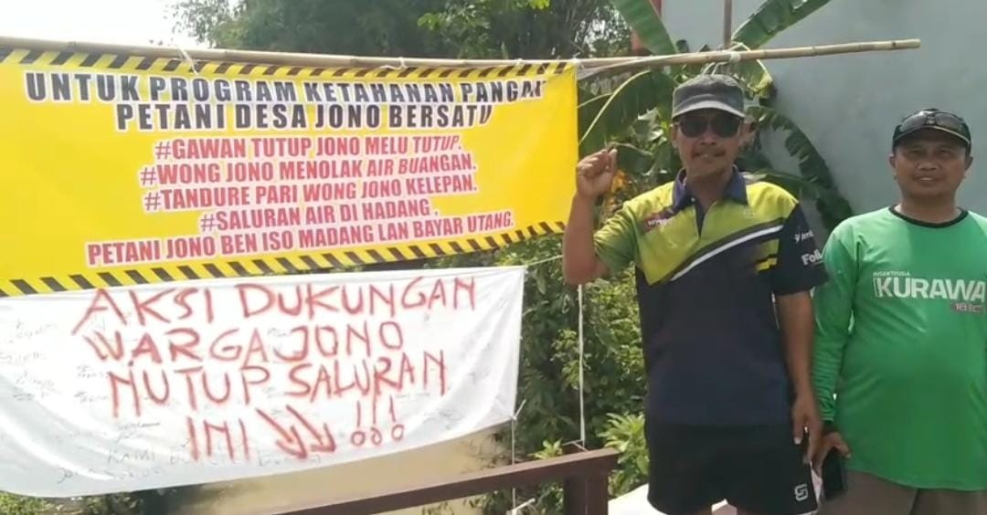 Petani Desa Jono, Kecamatan Tanon, Sragen membentangkan spanduk ancaman penutupan saluran air wilayah setempat, Senin (24/11/2025). (Ahmad Khairudin/Radar Solo)