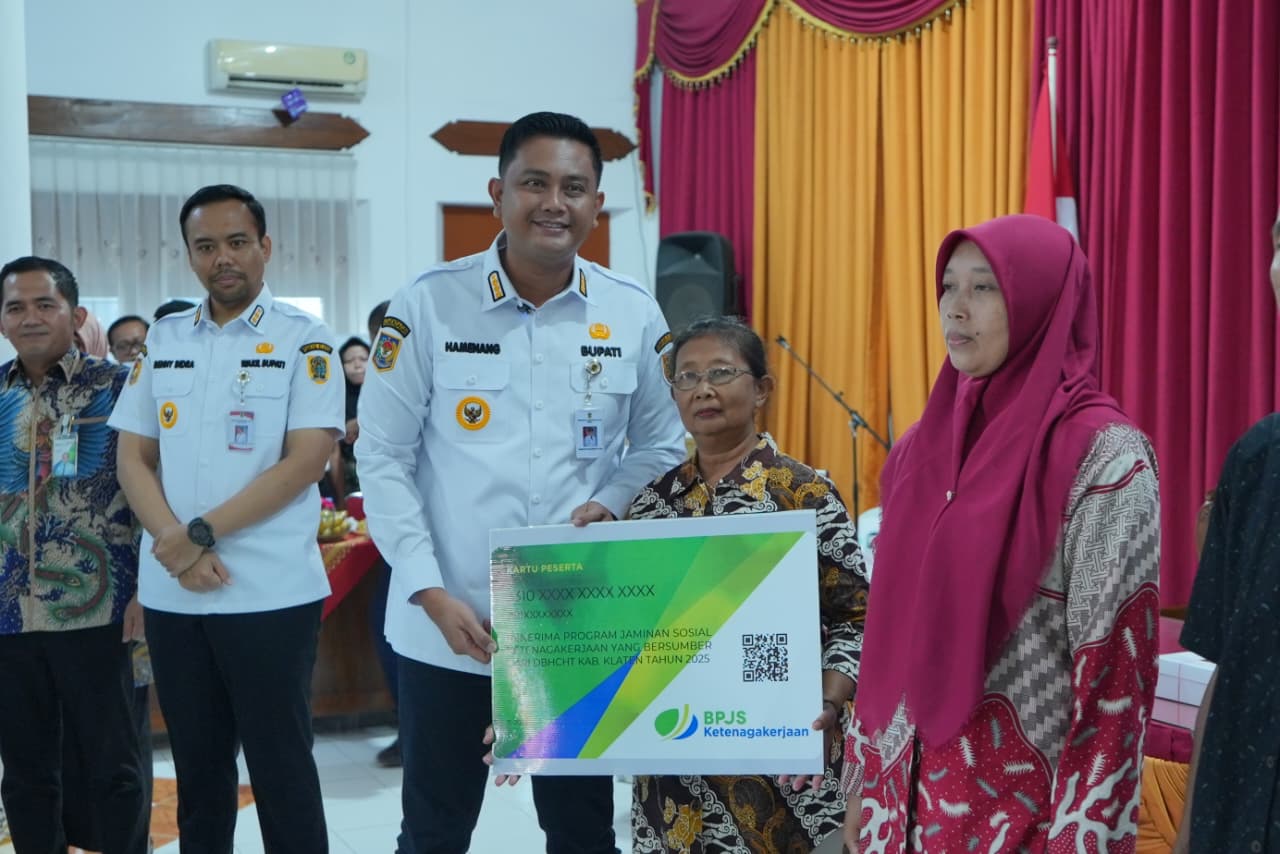 Bupati Klaten Hamenang Wajar Ismoyo saat menyerahkan kartu jaminan sosial ketenagakerjaan kepada sejumlah perwakilan penerima manfaat.