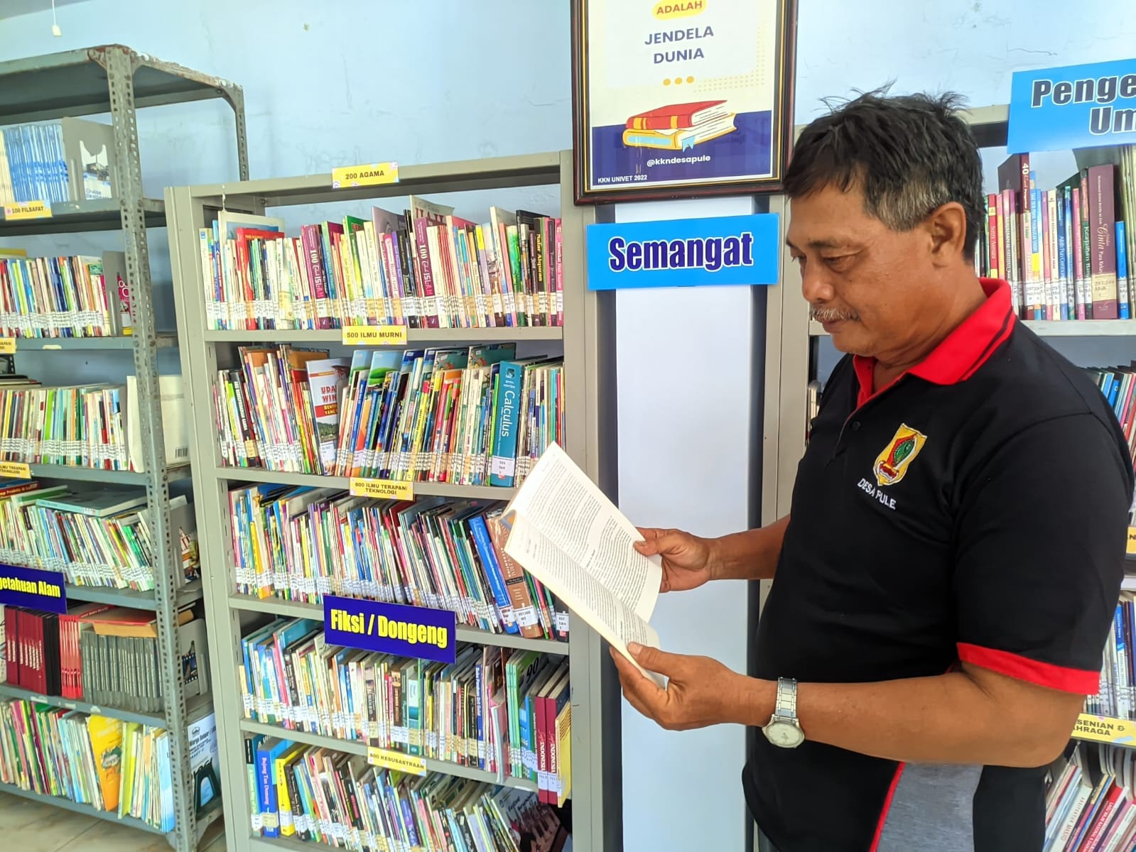 Kades Pule Sugimo di perpustakaan desa setempat. Minat baca warga terus dipacu.
