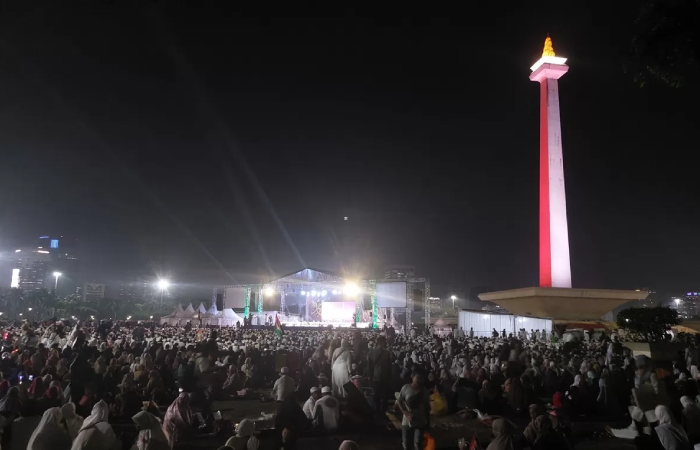 Peserta Reuni Akbar 212 menggelar doa bersama untuk korban banjir bandang dan longsor Sumatera di Monas, Selasa (2/12/2025).