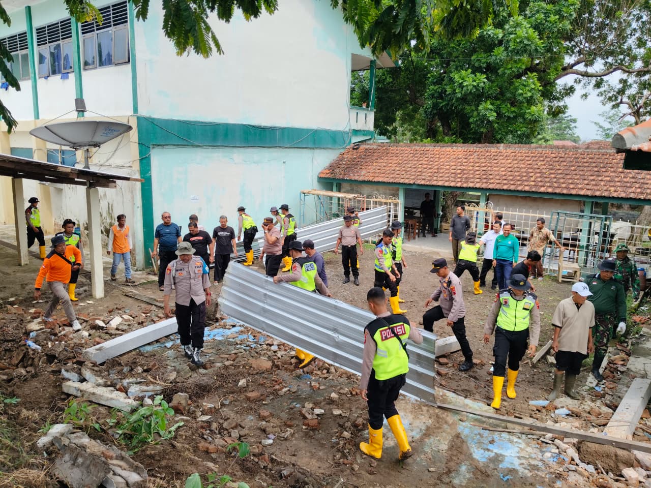 Jajaran Tim Siaga Bencana Bhayangkara Polres Klaten melakukan pembersihan puing-puing tembok SMAN 1 Polanharjo yang roboh akibat diguyur hujan deras beberapa waktu lalu. (Dok.Polres Klaten)
