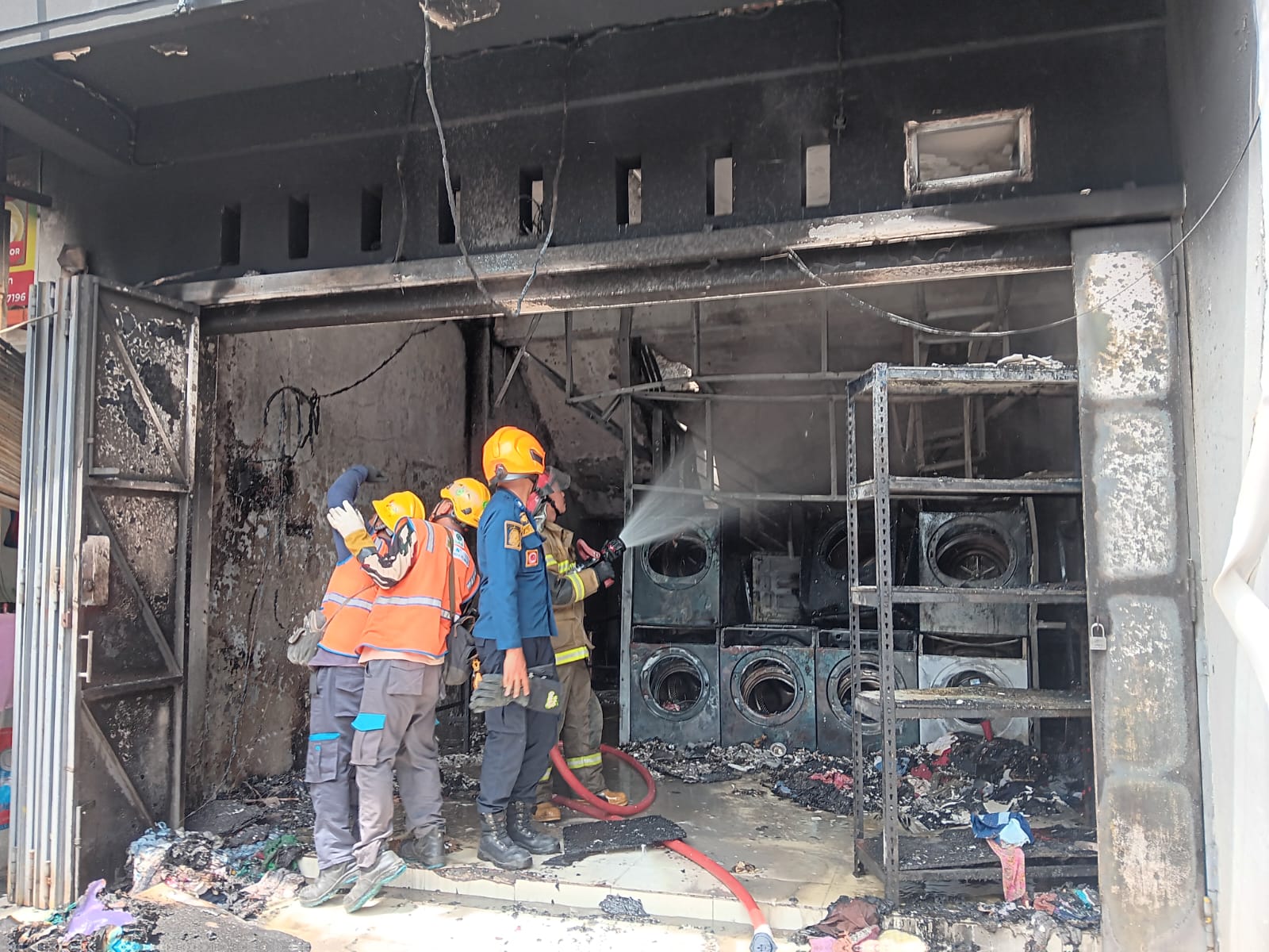 Petugas Damkar Klaten berupaya melakukan pemadaman api di ruko laundry Jalan Prenjak, Kelurahan Bareng, Kecamatan Klaten Tengah, Senin (8/12/2025). (Angga Purenda/Radar Solo)