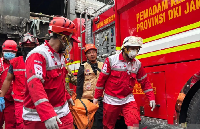 Petugas mengevakuasi jenazah korban kebakaran di gedung ruko Terra Drone di jalan Letjen Soeprapto, Cempaka Baru, Kemayoran, Jakarta Pusat, Selasa (9/12/2025).