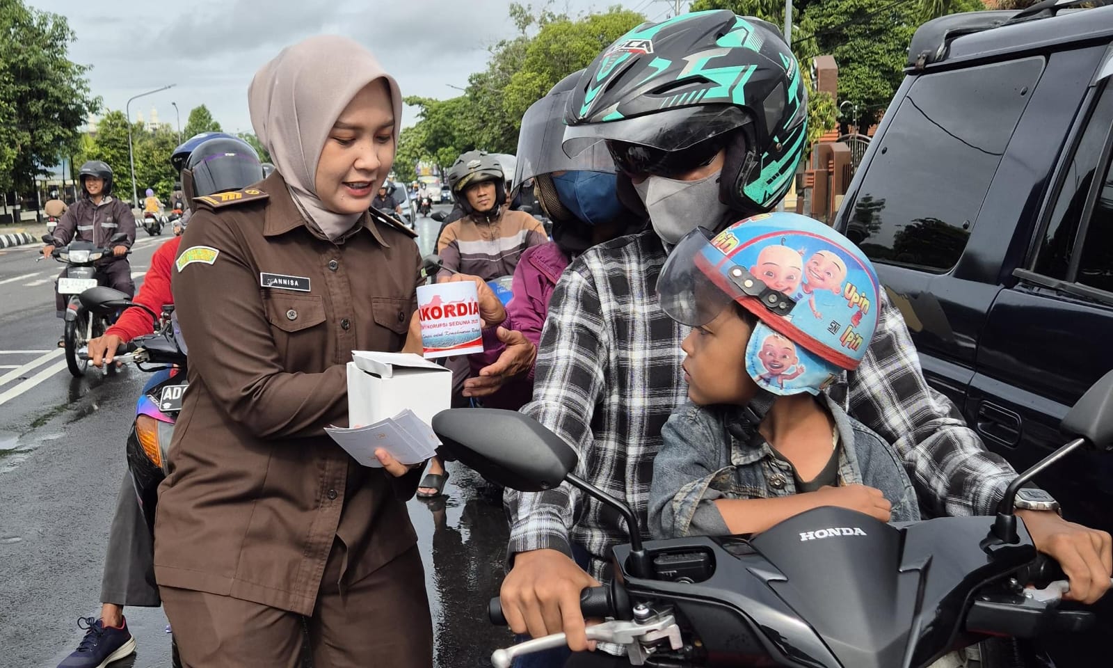 Kejari Karanganyar membagikan stiker dan mug bertema antikorupsi di Jalan Lawu, Karanganyar, Selasa (9/12/2025). (Ahmad Khairudin/Radar Solo)