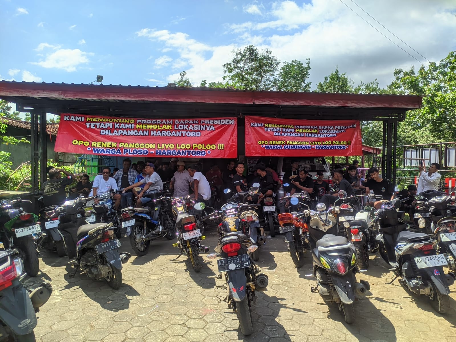 Warga memasang spanduk protes terkait pembangunan gedung KDMP di Lapangan Desa Hargantoro yang akhirnya lokasinya dipindah, Rabu (10/12/2025).