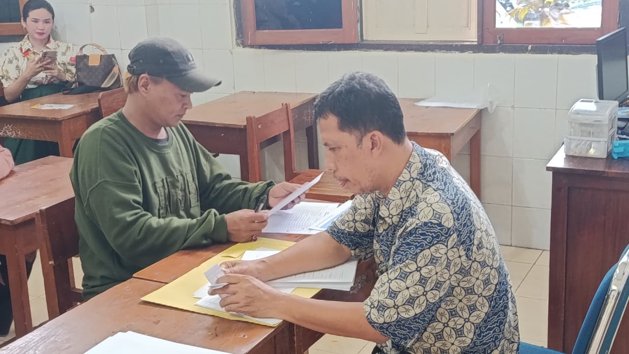 Seorang Ayah mengambil rapor semester I anaknya di SMPN 1 Solo, Kamis (18/12).