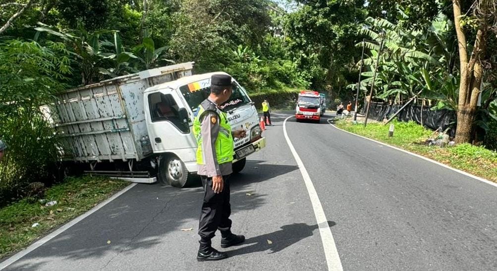 Kondisi truk yang terperosok ke selokan di Jalan Solo-Tawangmangu, Desa Nglebak, Kecamatan Tawangmangu, Karanganyar, Selasa (30/12/2025) pagi. (Rudi Hartono/Radar Solo)