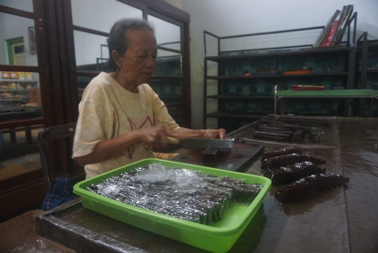 Peker memotong produk jenang ayu sebagai oleh-oleh para pembeli yang datang di Jenang Ayu Niten, Desa Gadungan, Kecamatan Wedi, Klaten.