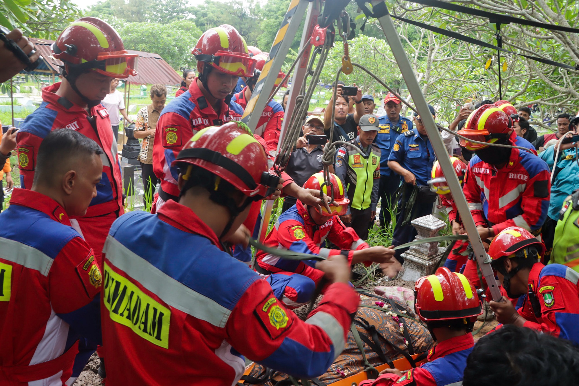 Petugas Damkar Kota Solo bekerja keras untuk memakamkan jenazah Rusminingsih yang berobot 200 kg. (M Ihsan/Radar Solo)