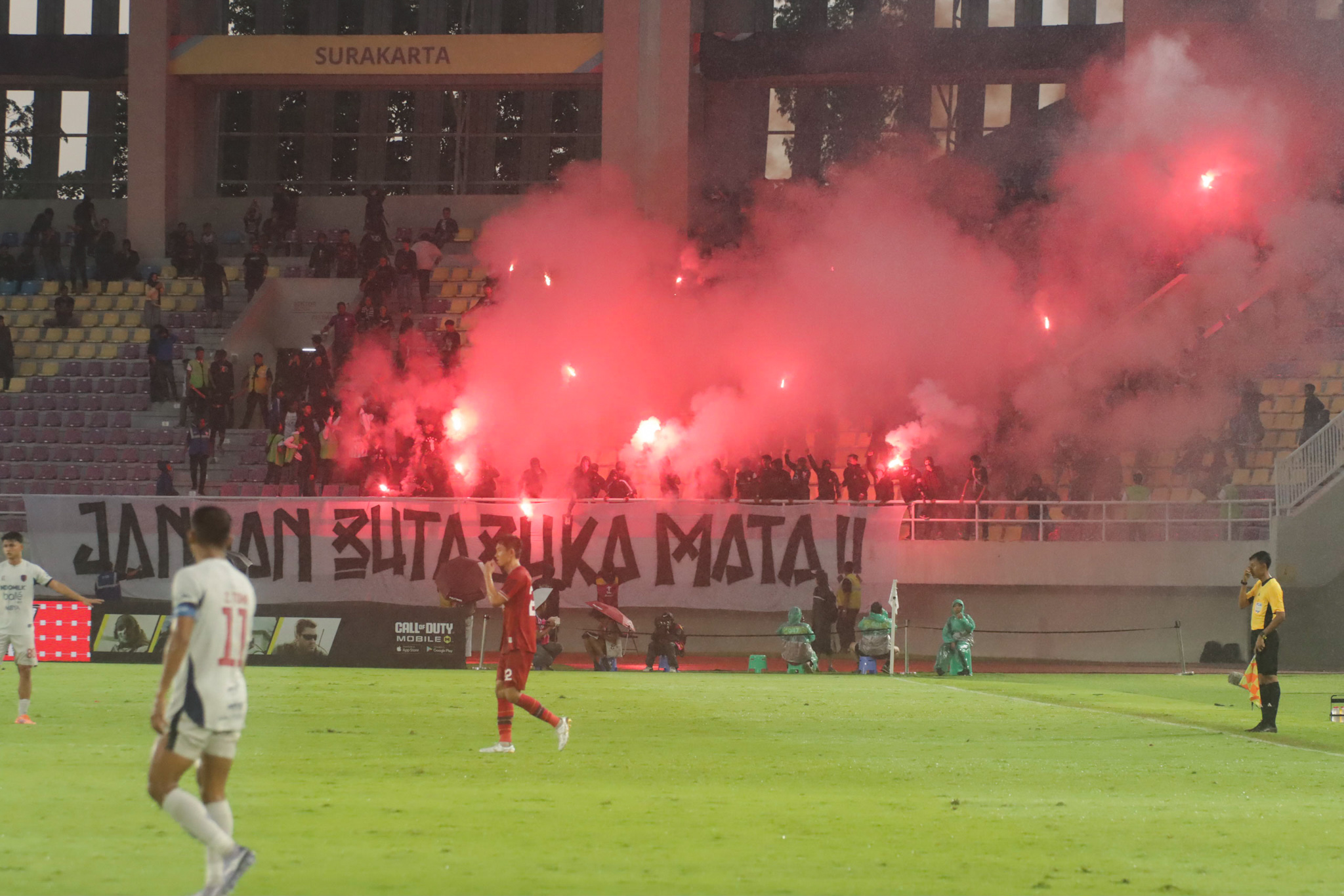 Suporter Persis Solo menyalakan flare di Stadion Manahan, dalam laga lanjutan Super League.