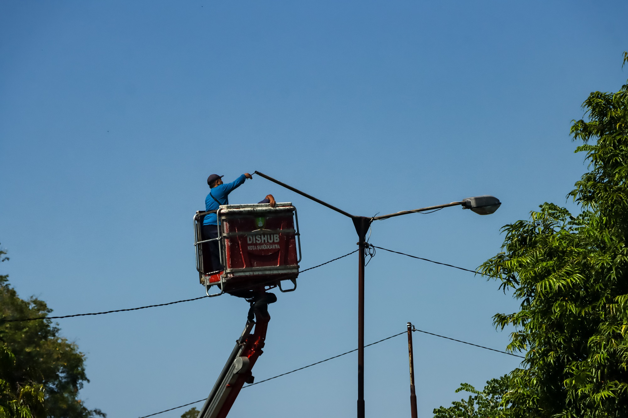 Petugas sedang memperbaiki PJU di Kota Solo. (M Ihsan/Radar Solo)