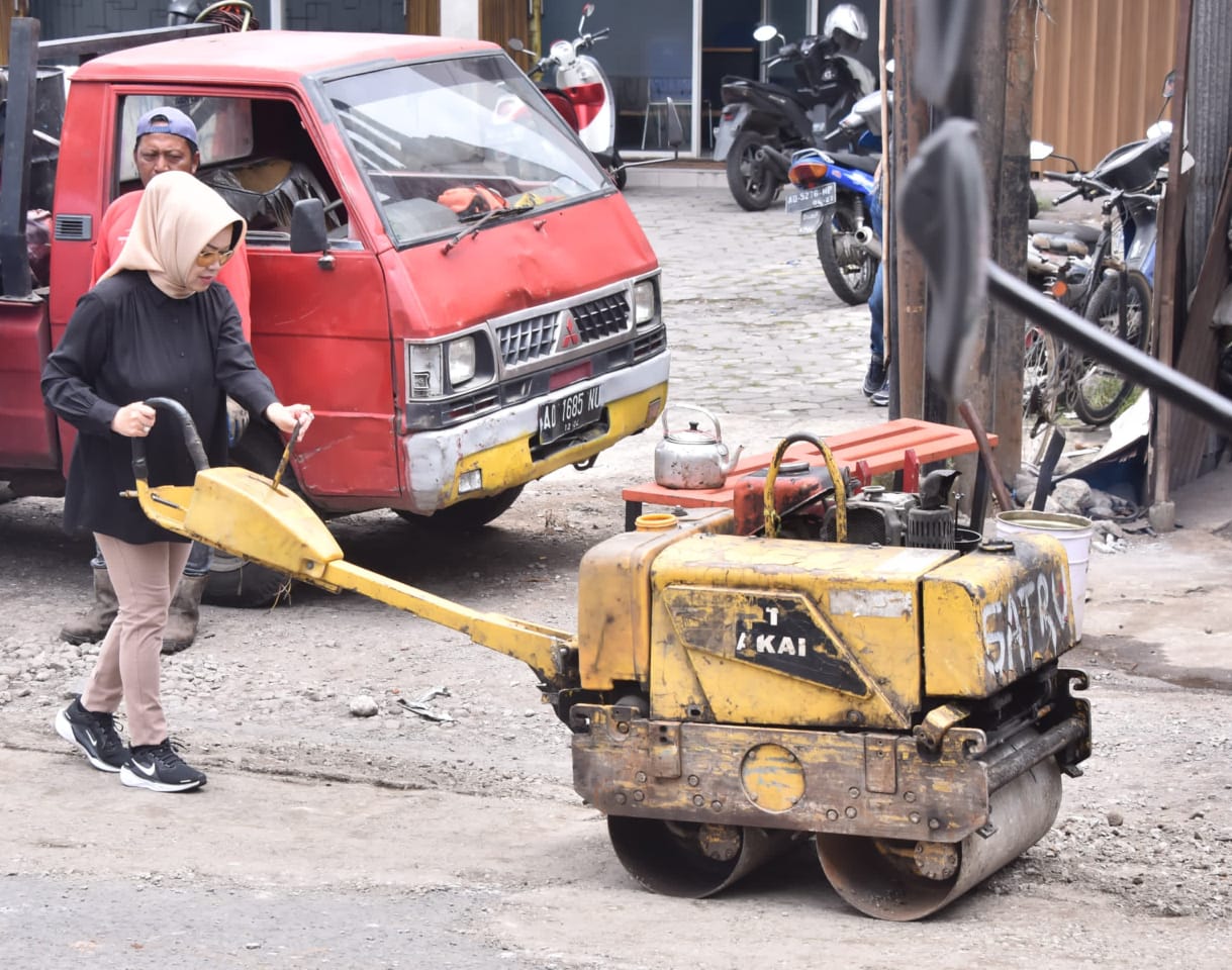 Bupati Sukoharjo Etik Suryani operasikan hand roller saat perbaikan jalan di Bendosari, beberapa waktu lalu.