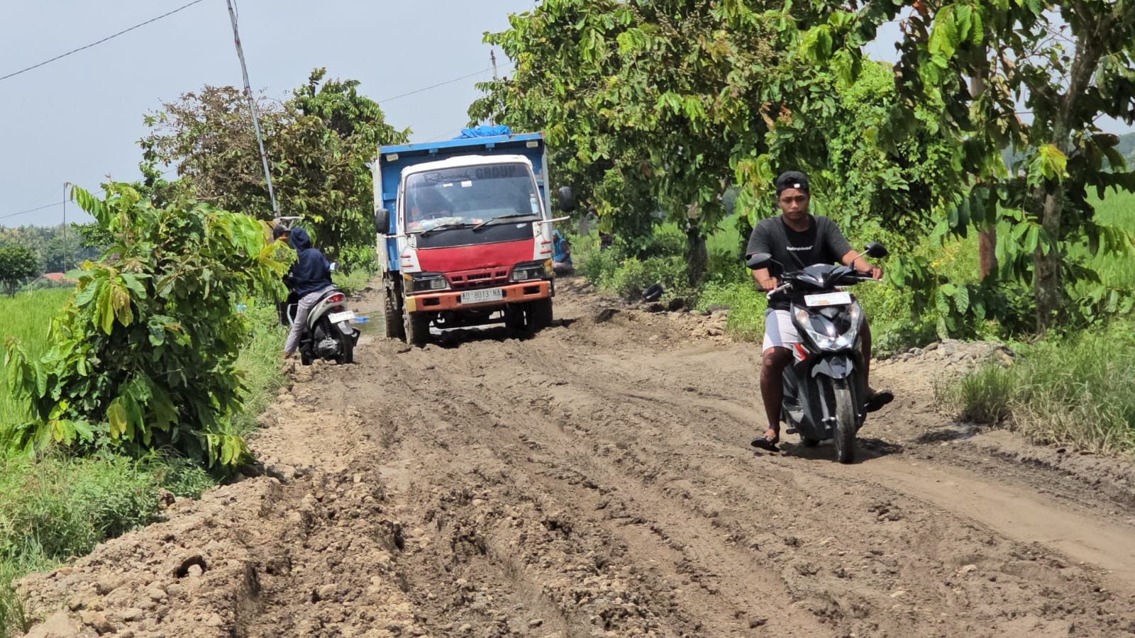 Sejumlah pengendara melintasi jalan Tanon-Gading di Desa Gading, Kecamatan Tanon, Sragen yang berlumpur, Selasa (13/1/2026). (Ahmad Khairudin/Radar Solo)