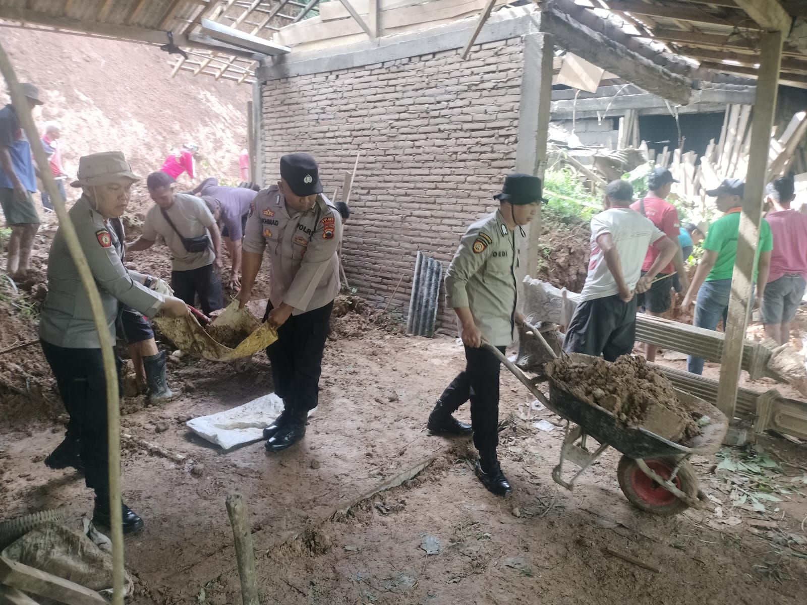 Warga dan aparat bergotong royong bersihkan material longsor yang menerjang rumah warga Lingkungan Jambangan RT 03 RW 03, Kelurahan Balepanjang, Jatipurno, Wonogiri, Selasa (13/1/2026).
