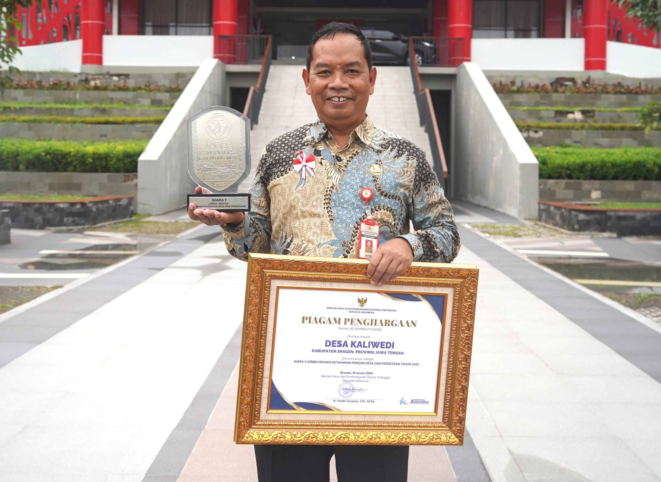 Kepala Desa Kaliwedi, Daryono tunjukkan piala penghargaan Hari Desa Nasional. (Dokumentasi Pribadi)