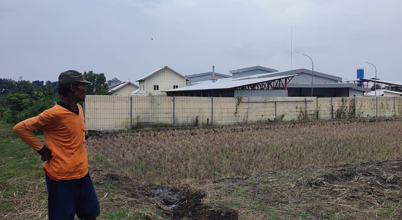 Warga menunjukkan lahan persawahan di Sragen yang kini berdiri pabrik. (Ahmad Khairudin/Radar Solo)