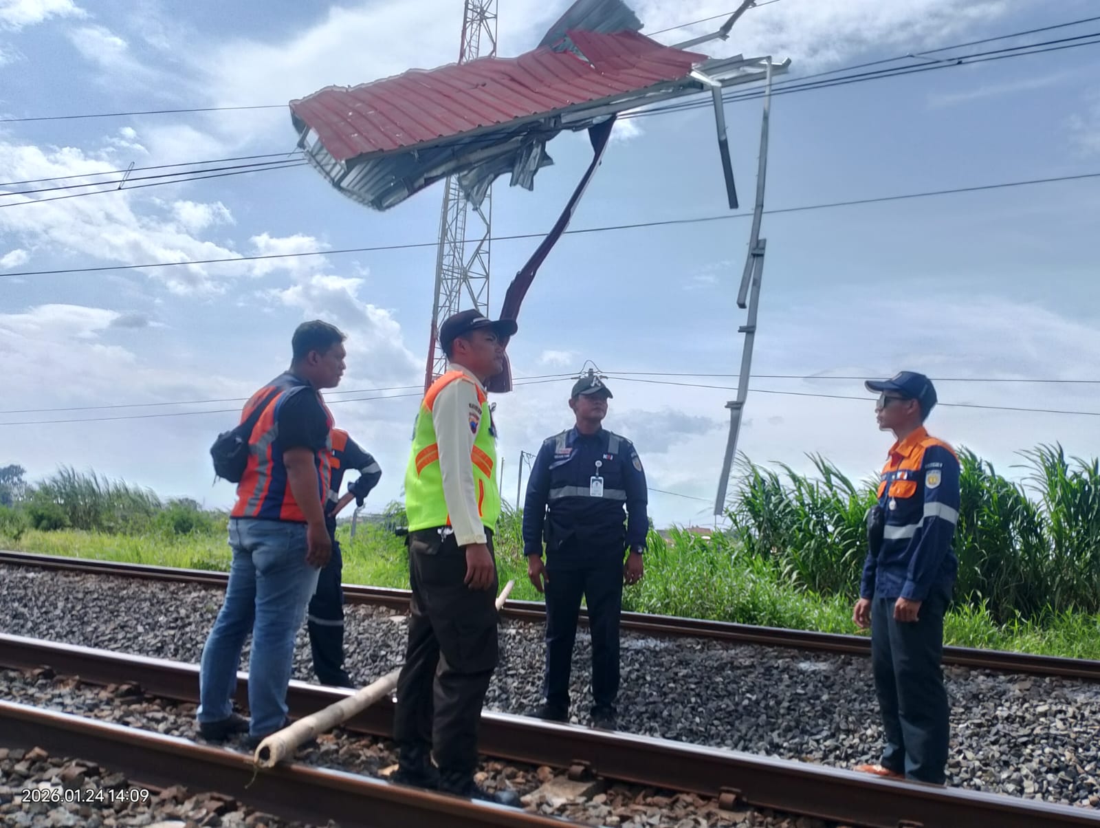 Proses evakuasi atap galvalum yang tersapu angin yang nyangkut di tiang listrik KRL di dekat Stasiun Gawok, Gatak, Sukoharjo, Sabtu (24/1).