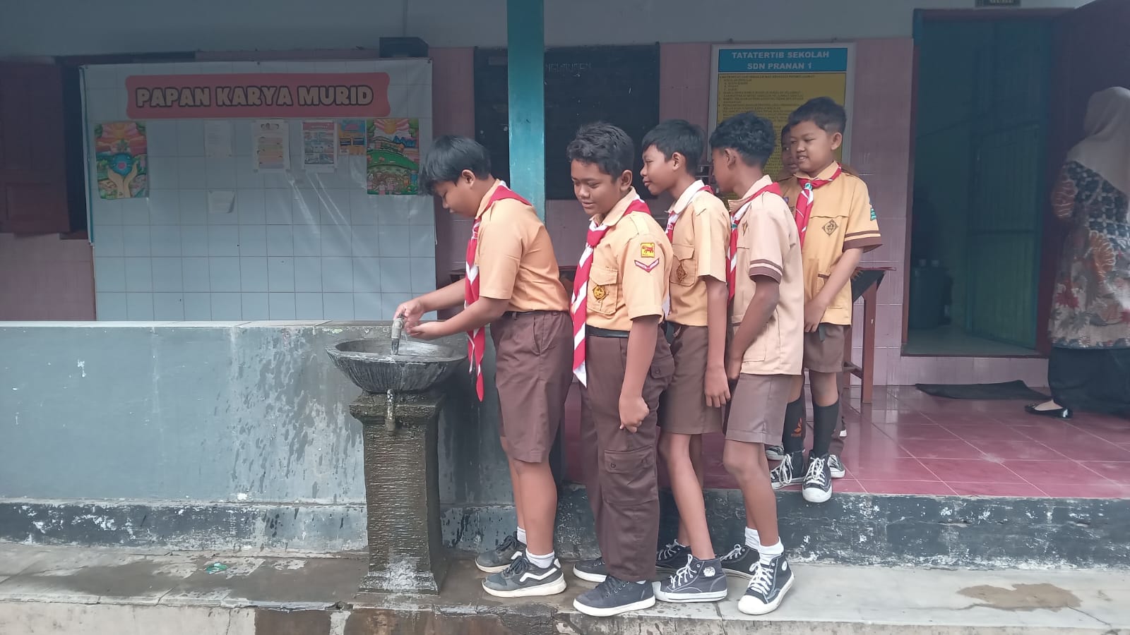 Pelajar SDN 1 Pranan, Kecamatan Polokarto berbaris hendak mencuci tangan dengan sabun dan air bersih sebelum menyantap menu makan bergizi gratis (MBG), Senin (26/1).