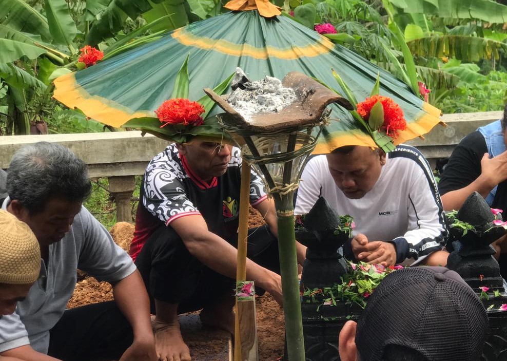 Purwanto (kaos putih) di depan pusara AO, buah hatinya yang meninggal gara-gara dibunuh rampok yang tak lain tetangganya sendiri, Jumat (30/1/2026).