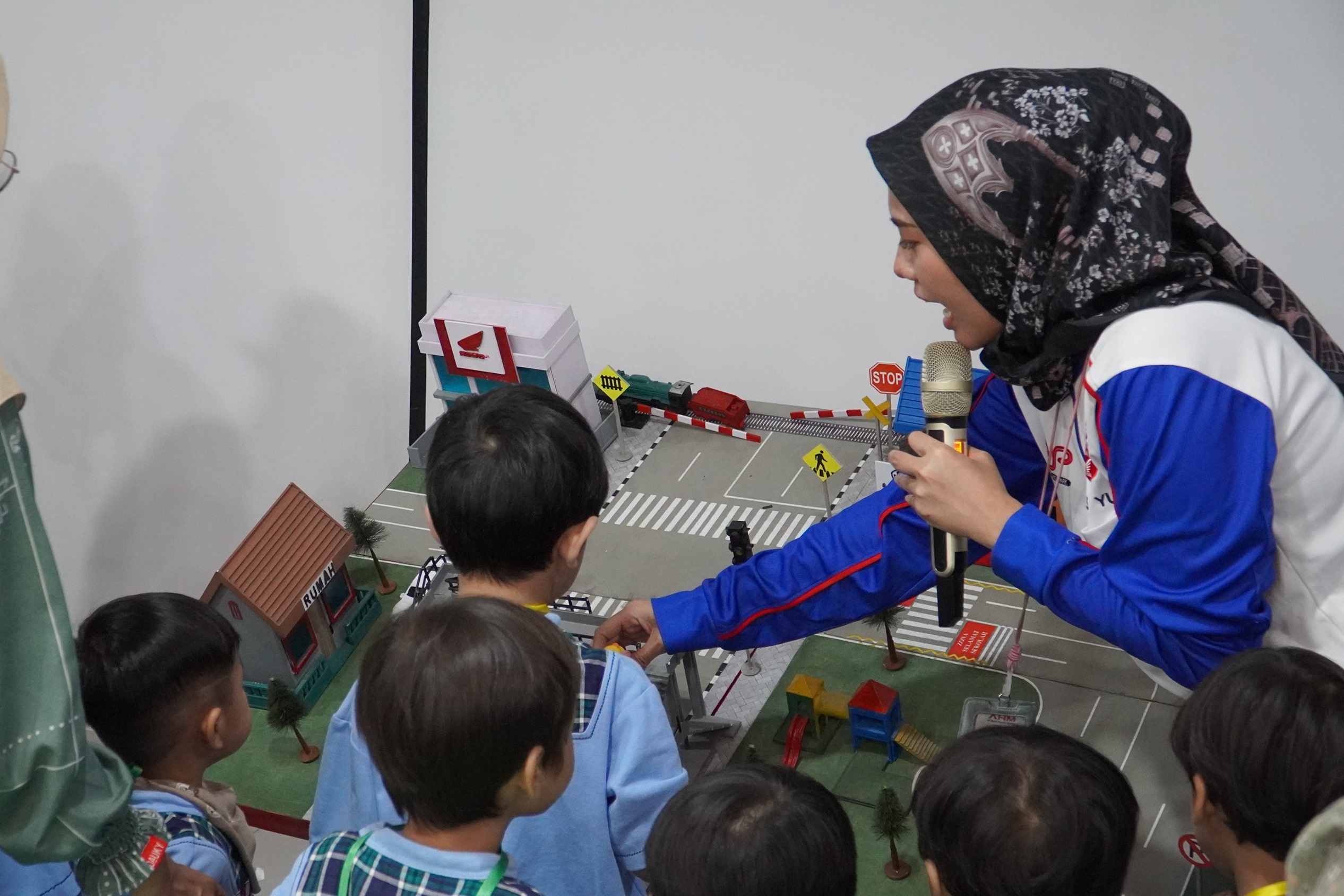 Instruktur Safety Riding Astra Honda mengedukasi anak usia dini lewat miniatur lalu lintas dan praktik di area kids AHM Safety Riding Center Deltamas.