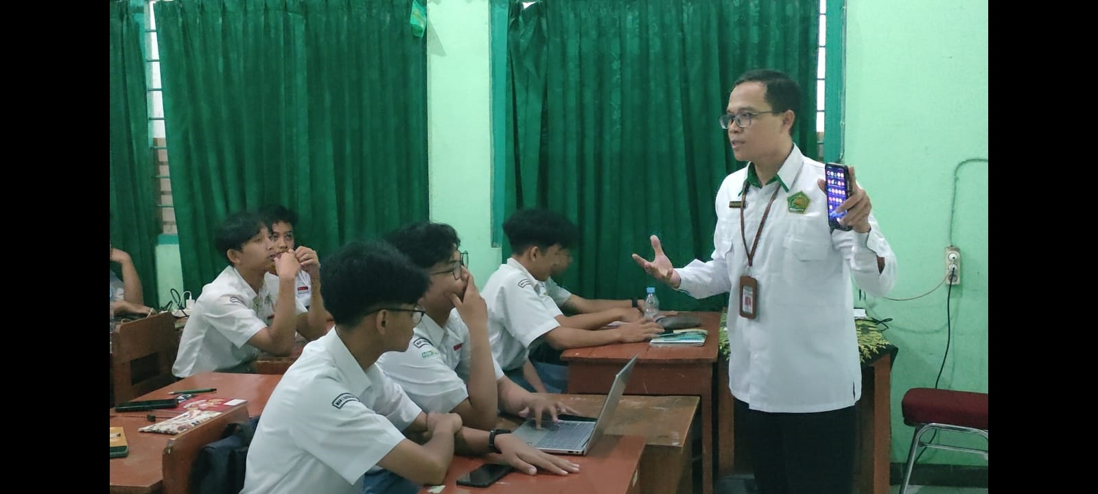 Rusdi Mustapa, guru MAN 1 Solo memprakktikkan cara menggunakan AI untuk belajar sejarah. (Silvester Kurniawan/Radar Solo)