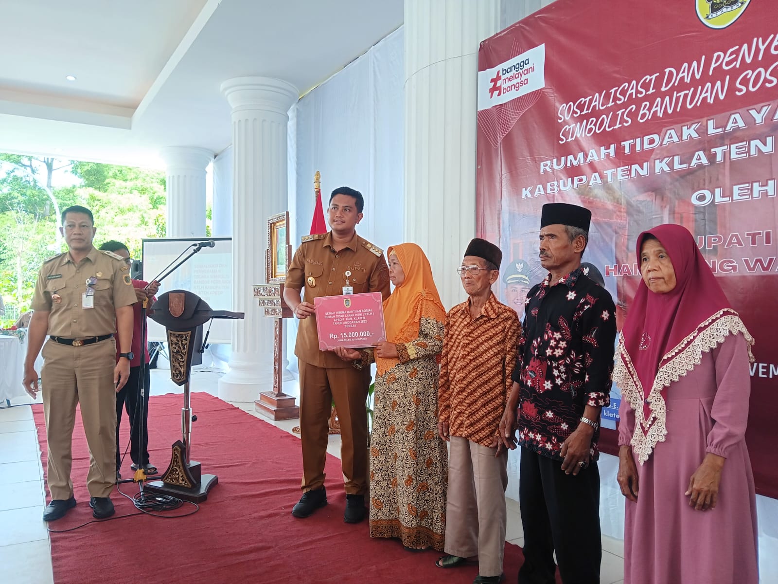 Ilustrasi Bupati Klaten Hamenang Wajar Ismoyo saat menyerahkan bantuan rehab RTLH 2025 kepada perwakilan penerima
