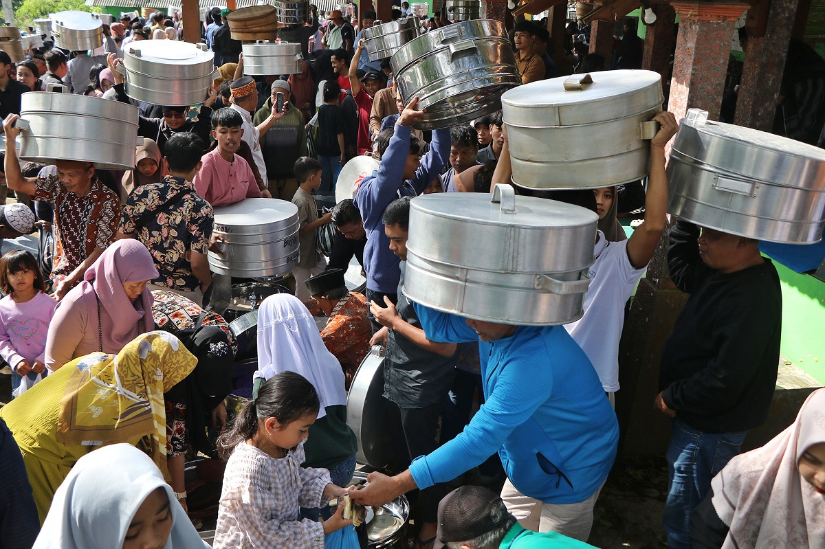 Warga Desa Sukabumi, Kecamatan Cepogo, Boyolali tumpah ruah dalam tradisi Sadranan. Mereka membawa aneka makanan yang diwadahi tenong untuk disantap bersama.