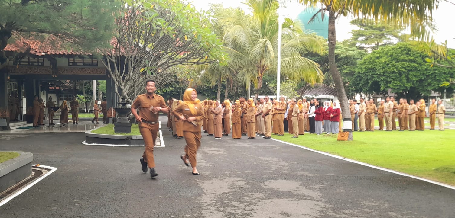 Dua PNS Pemkab Karanganyar keliling halaman kantor bupati setelah menerima SK PNS, Senin (9/2/2026), wujud kesiapan fisik dan mental jadi PNS. (Rudi Hartono/Radar Solo)
