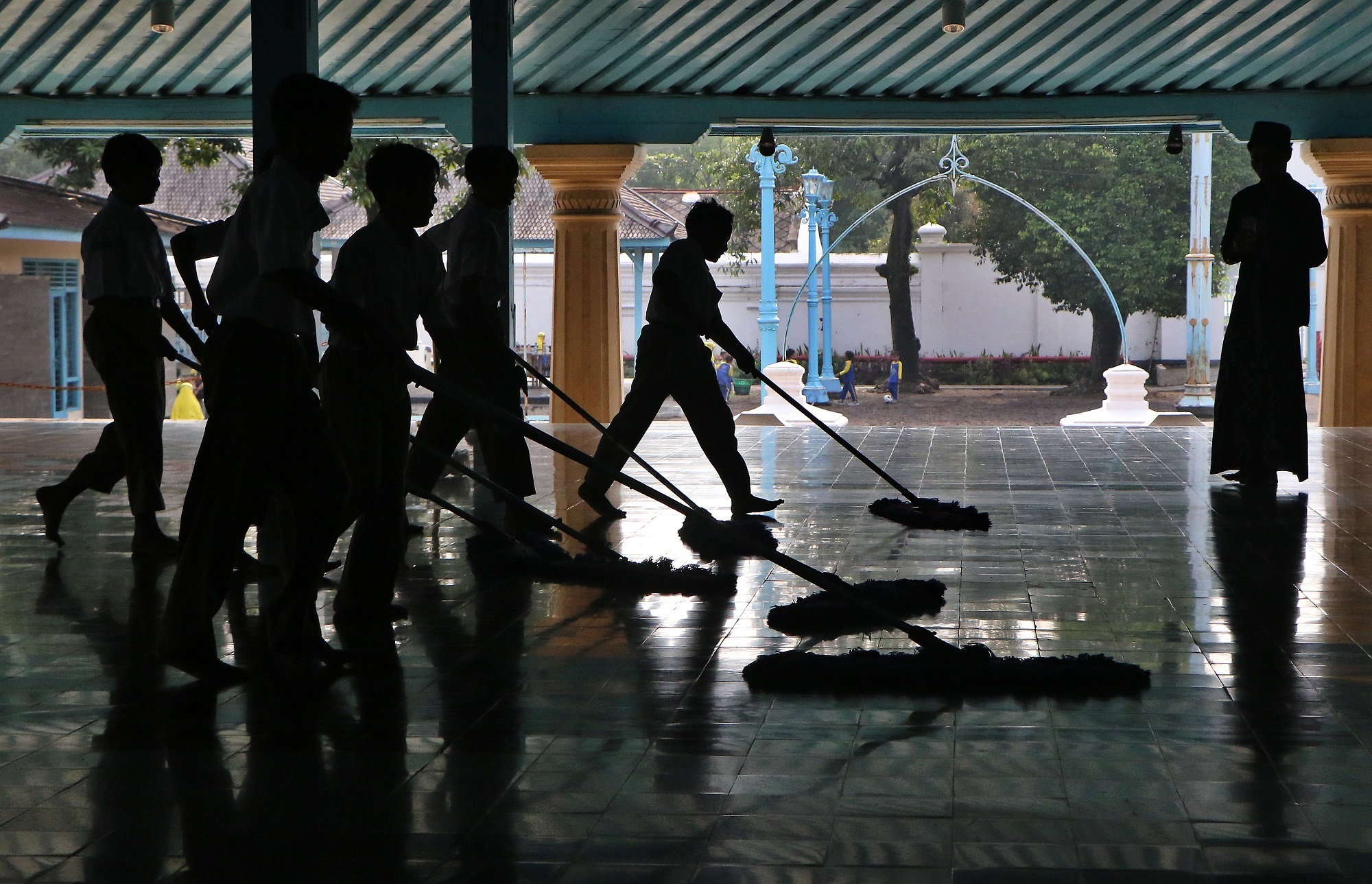 Siswa sekolah dasar di Kauman, Pasar Kliwon, membersihkan Masjid Agung Solo. (Arief Budiman/Radar Solo)