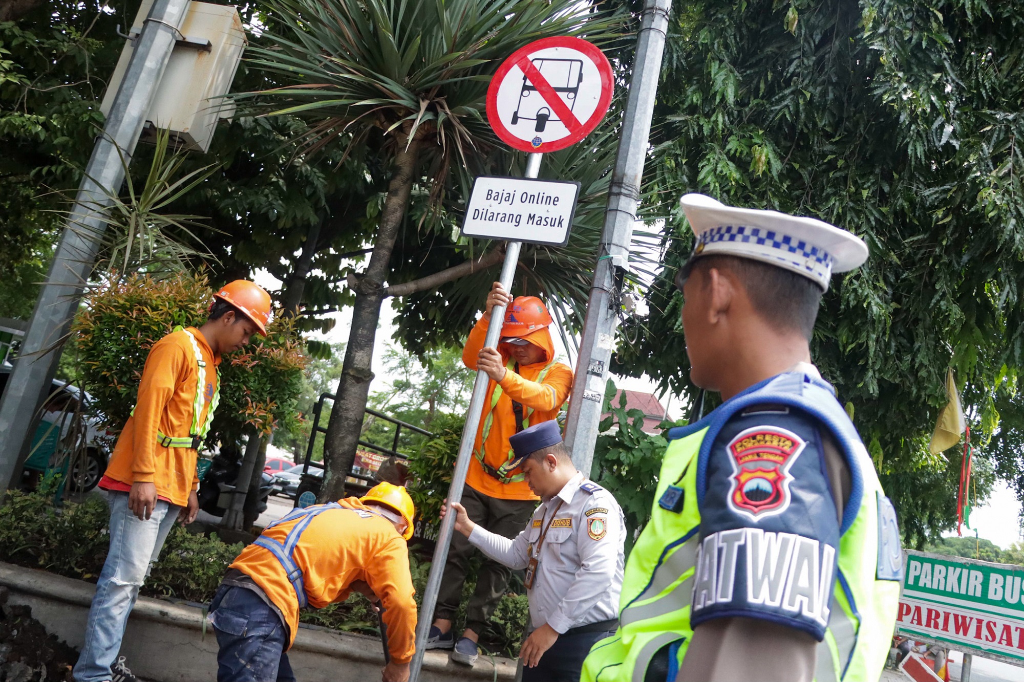 Petugas Dishub Kota Solo memasang rambu larangan bajaj melintas. (M Ihsan/Radar Solo)