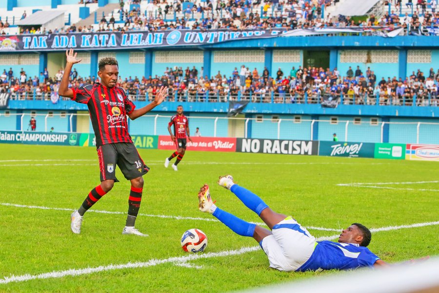 LAGA SENGIT: Pemain Persiku Hugo Samir (kanan) terjatuh usai berebut bola dengan pemain Persipura Alex Dusay (kiri)  
