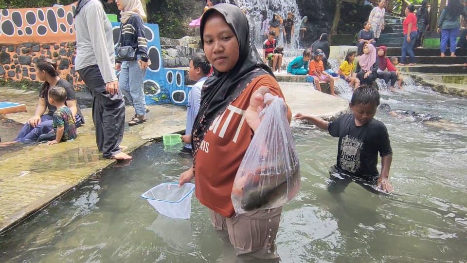 Pengunjung tunjukkan hasil tangkapan ikan di obyek wisata air Panorama, Selasa (17/2/2026).