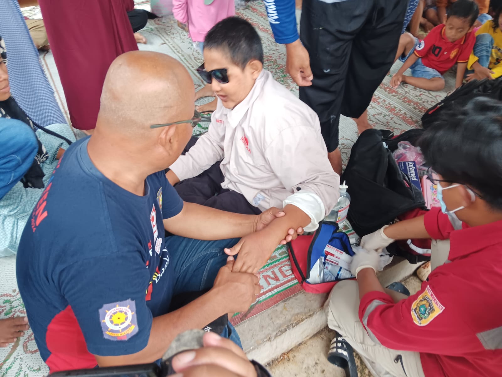 Penanganan luka pada tangan kiri korban oleh PMI Klaten akibat tersangkut pelat besi saluran pembuangan air di dalam kamar mandi Umbul Pelem, Desa Wunut, Kecamatan Tulung, Klaten, Selasa (17/2/2025).