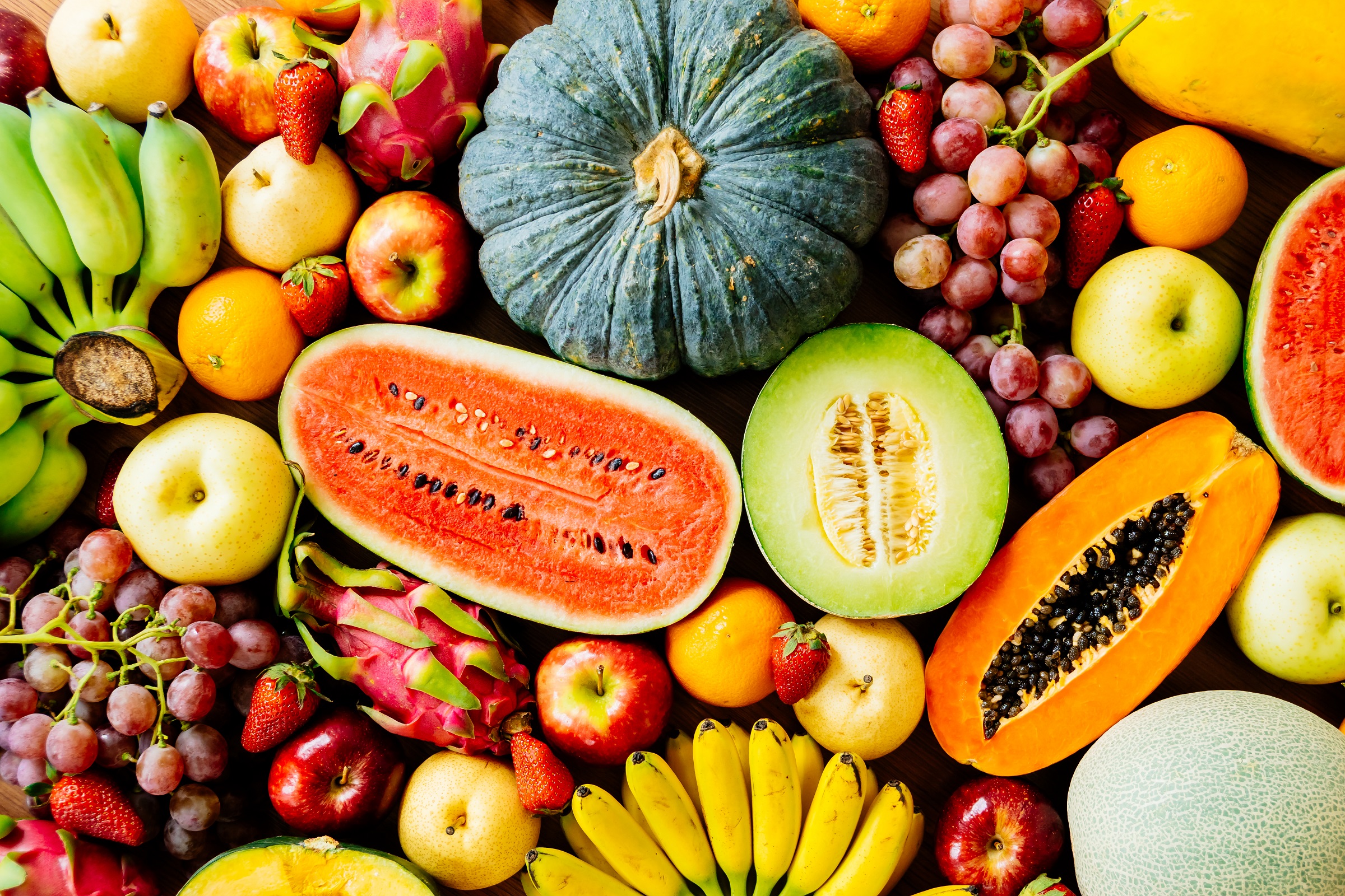 Assorted and mixed fruits on wooden background with copy space - Healthy food concept