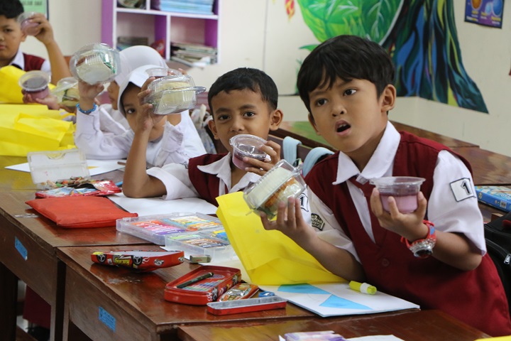 Siswa SDN Joglo No. 76 Solo menerima menu makan bergizi gratis berupa makanan kering saat bulan puasa di sekolah setempat, Senin (23/2).