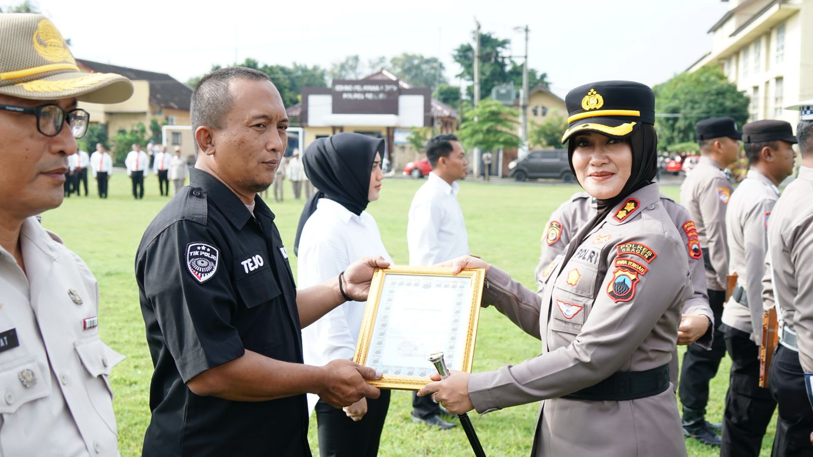 Kapolres Sragen AKBP Dewiana Syamsu Indyasari (kanan) menyerahkan penghargaan kepada anggota berprestasi, Senin (23/2/2026). (Ahmad Khairudin/Radar Solo)