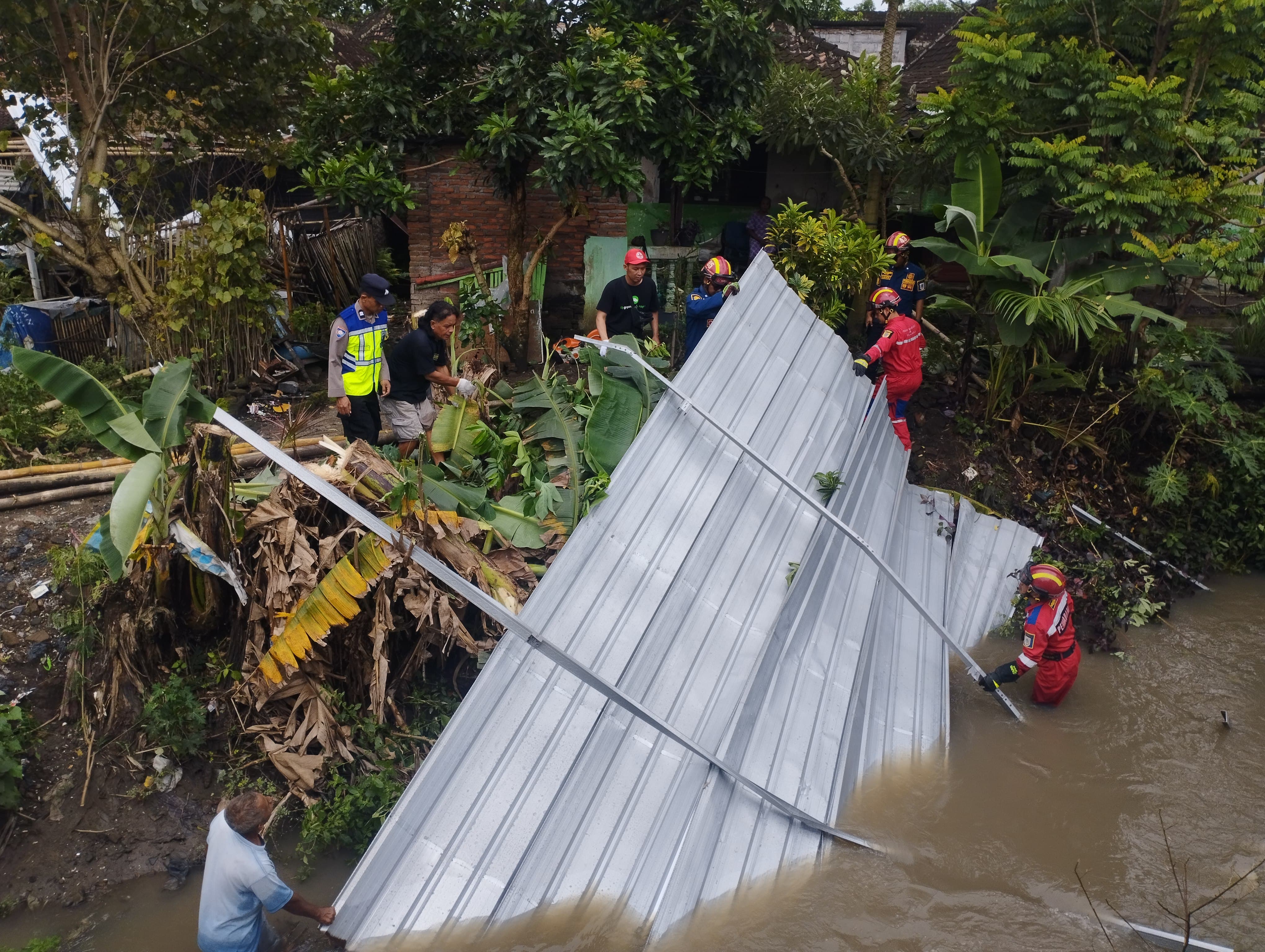 Penanganan atap tempat parkir masjid Desa Ngreden, Kecamatan Wonosari, Klaten yang terbang lalu terjebur ke sungai.