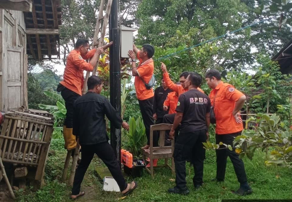 Personel BPBD Karanganyar melakukan pengecekan EWS di daerah rawan longsor Desa Menjing, Kecamatan Jenawi, Kamis (26/2/2026) siang. (Rudi Hartono/Radar Solo)