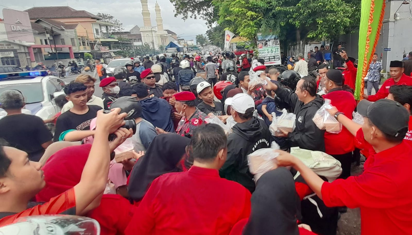 Pengurus dan kader DPC PDIP Karanganyar membagikan 1.000 takjil ke masyarakat di Jalan Lawu, Karanganyar, Jumat (27/2/2026). (Rudi Hartono/Radar Solo)