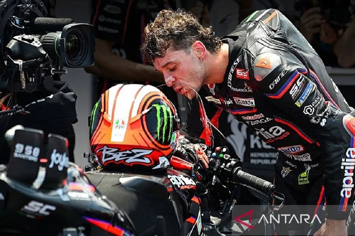 Pebalap Aprilia Racing Marco Bezzecchi mencium motor Aprilia RS-GP25. 