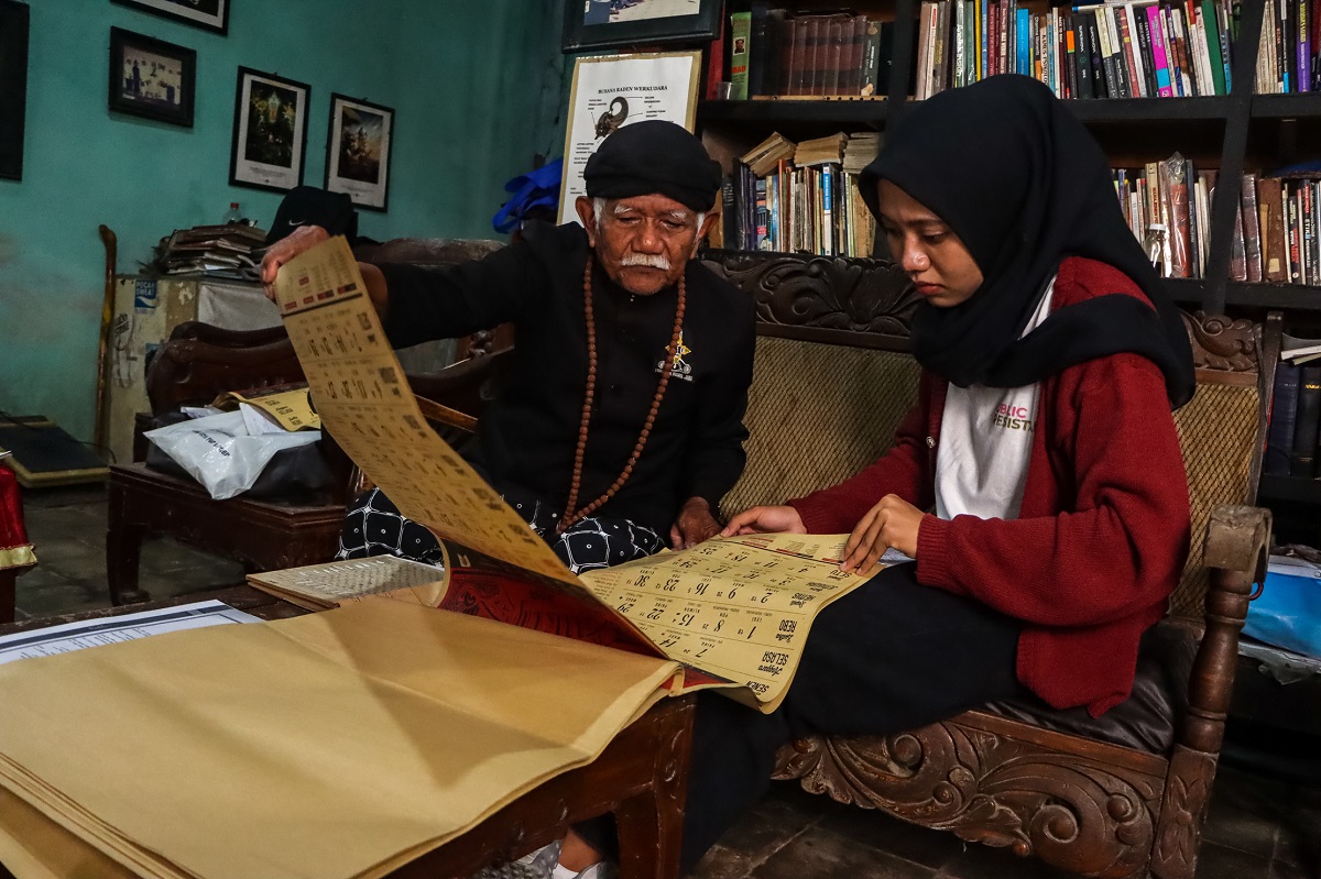Mardiwiyoto atau yang akrab disapa Mbah Mardi (kiri) tetap setia melestarikan kalender Jawa.