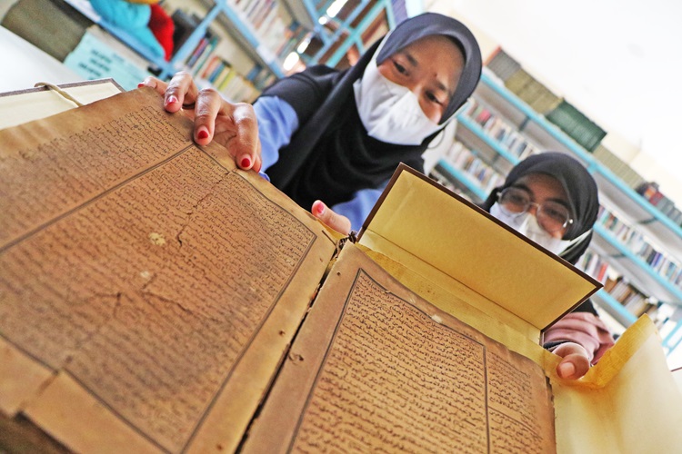 Pengunjung mengamati manuskrip Alquran kuno koleksi Perpustakaan Masjid Agung Surakarta. Pendidikan Islam dalam perspektif Alquran ajarkan kelembutan.