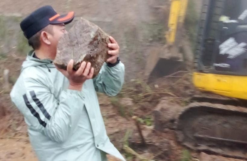 Bupati Karanganyar Rober Christanto ikut mengangkat batu material longsor di jalan tembus Tawangmangu, Kamis (5/3/2026). (Rudi Hartono/Radar Solo)