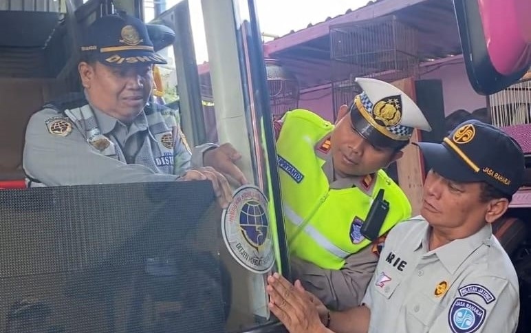 Dishub Sragen memasang stiker tanda layak jalan bagi bus angkutan Lebaran, Selasa (10/3/2026). (Ahmad Khairudin/Radar Solo)