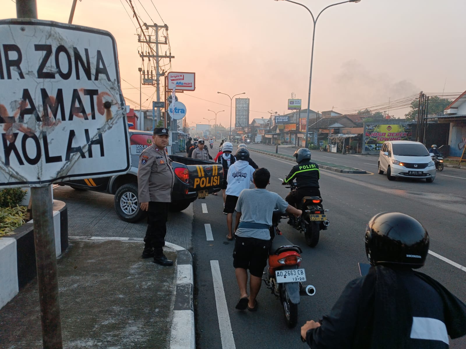 Peserta Aftar Sahur Ride di Jalan Ahmad Yani Kartasura, Sukoharjo mendorong motornya ke Mapolsek Kartasura usai keciduk polisi, Minggu pagi (15/3).