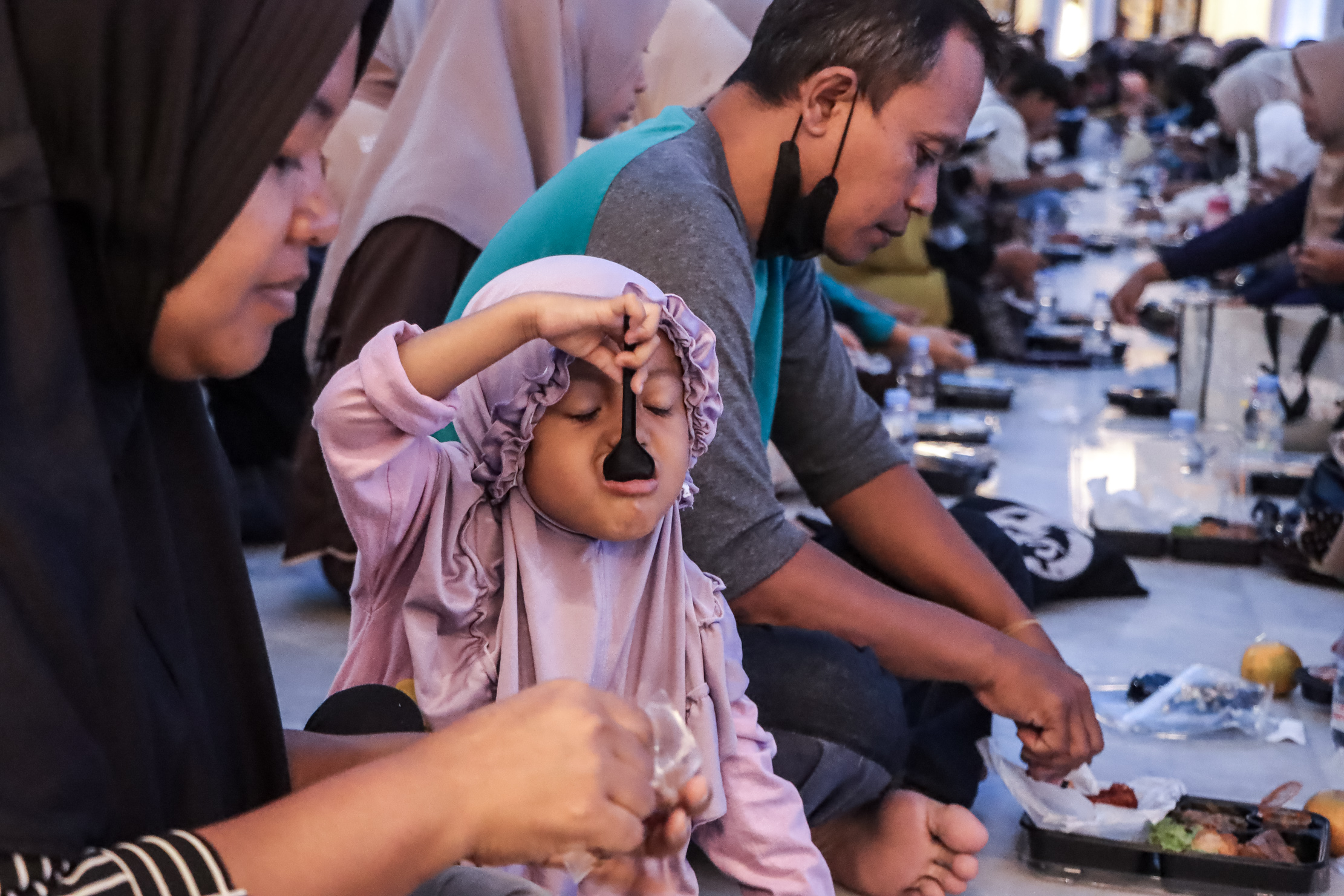 Ilustrasi seorang ibu menyuapi anaknya saat berbuka puasa bersama ribuan jamaah lainnya di Masjid Raya Sheikh Zayed Solo, Minggu (15/3).
