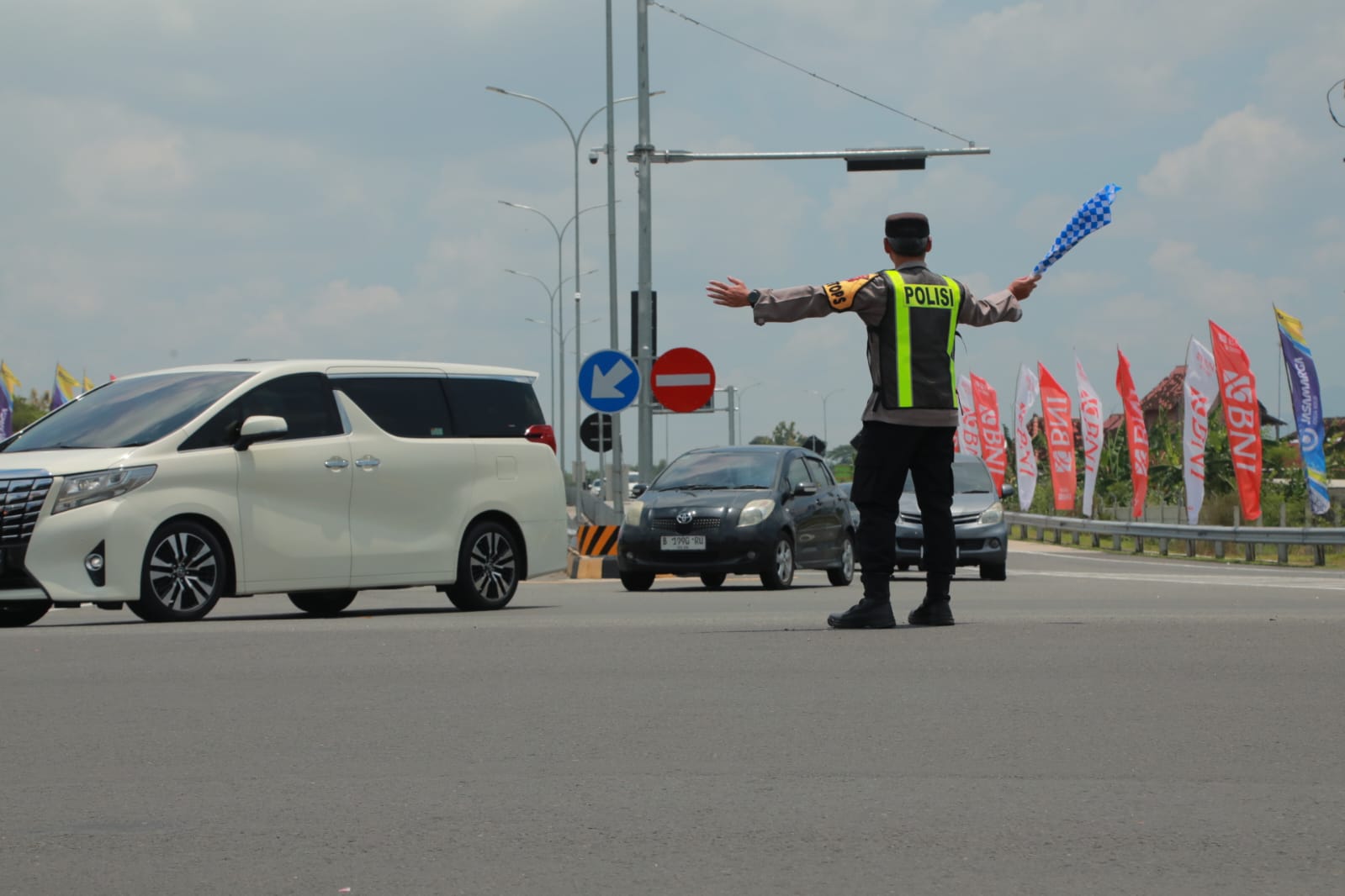 Anggota Polres Klaten mengatur pertemuan arus kendaraan di exit tol Prambanan, Klaten. 
