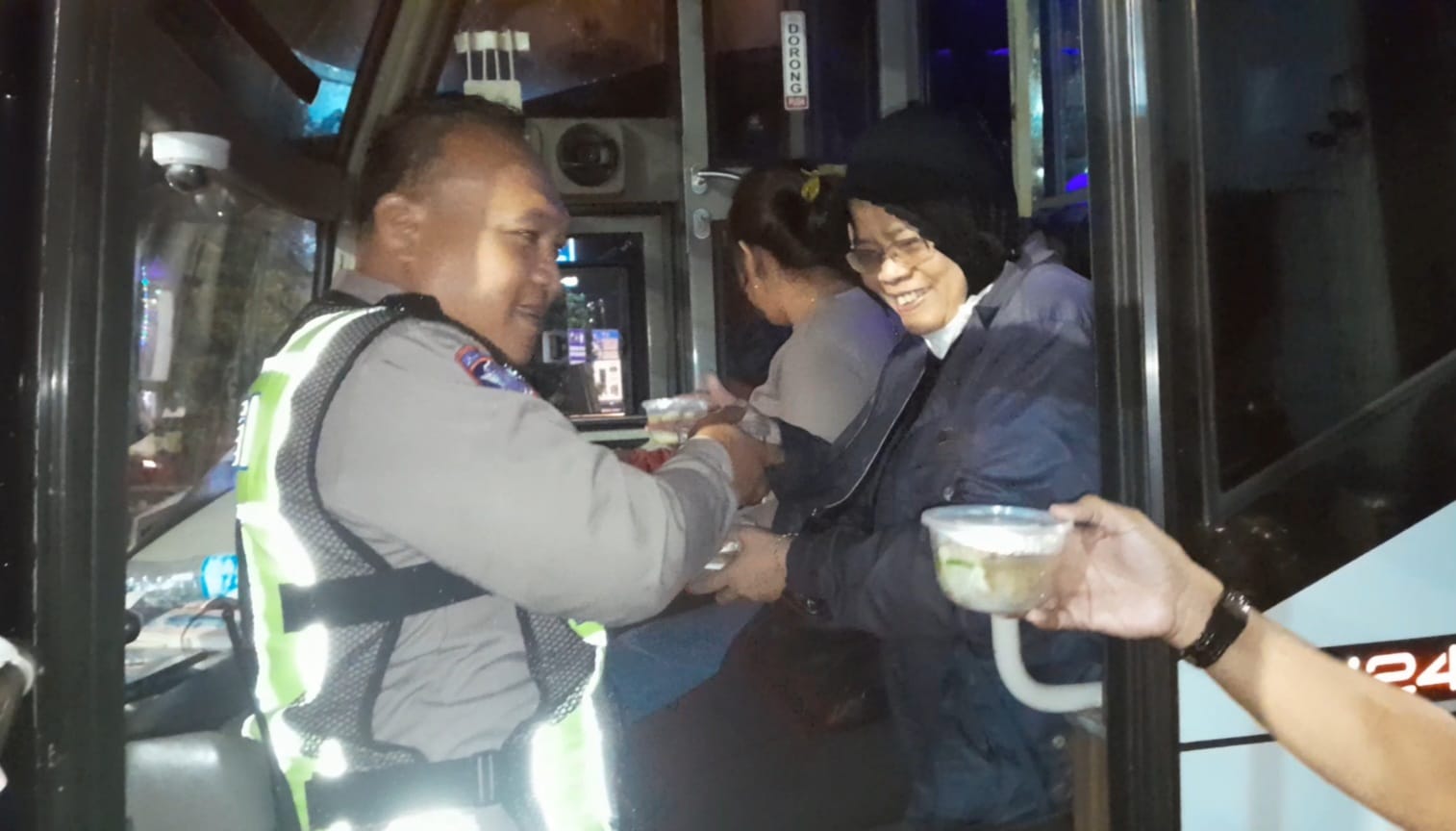 Petugas gabungan Pospam 3 Tugu Kartasura bagikan bakso gratis kepada pemudik yang diangkut bus, Selasa malam (24/3).